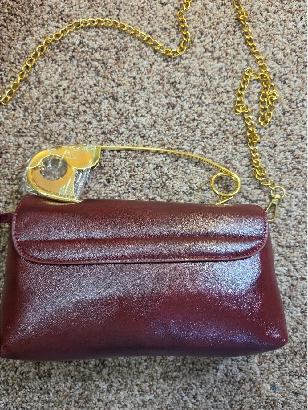 Elegant Burgundy Faux Leather Clutch Bag with Gold Chain and Safety Pin Detail